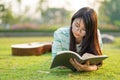 Teenage girl wearing glasses lying down with guitar and books On the field at sunset. Royalty Free Stock Photo