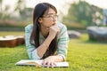 Teenage girl wearing glasses lying down with guitar and books On the field at sunset. Royalty Free Stock Photo