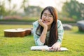 Teenage girl wearing glasses lying down with guitar and books On the field at sunset. Royalty Free Stock Photo