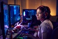 Teenage Girl Wearing Headset Gaming At Home Using Dual Computer Screens Royalty Free Stock Photo