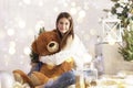 teenage girl in winter clothes, smiling, posing cutely hugging a huge teddy bear, Royalty Free Stock Photo