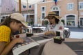 A teenage girl and a woman read a menu in a restaurant on a street in Rome