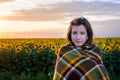 Teenage Girl Wrapped in Blanket in Sunflower Field