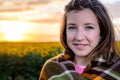 Teenage Girl Wrapped in Blanket in Sunflower Field