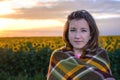 Teenage Girl Wrapped in Blanket in Sunflower Field