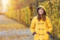 Teenage girl in a yellow hooded coat in Augarten park autumn season Vienna
