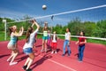 Teenage girls and boy play together volleyball