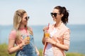 Teenage girls or friends with drinks in summer Royalty Free Stock Photo