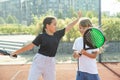 Teenage girls with racquets and balls standing in padel court, looking at camera and smiling. Royalty Free Stock Photo