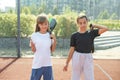 Teenage girls with racquets and balls standing in padel court, looking at camera and smiling. Royalty Free Stock Photo