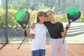 Teenage girls with racquets and balls standing in padel court, looking at camera and smiling. Royalty Free Stock Photo