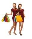Teenage girls in red dresses with shopping bags Royalty Free Stock Photo