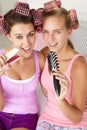 Teenage girls singing into hairbrushes Royalty Free Stock Photo