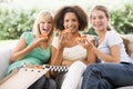 Teenage Girls Sitting On Couch And Eating Pizza