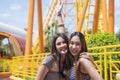 Teenage girls traveling in an amusement park. Two female are taking pictures of themselves in an amusement park Royalty Free Stock Photo