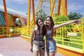 Teenage girls traveling in an amusement park. Two female are taking pictures of themselves in an amusement park Royalty Free Stock Photo