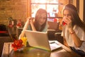 Teenage girls using laptop in cafe. Royalty Free Stock Photo