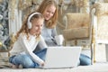 Portrait of teenage girls using laptop while sitting near Christmas tree Royalty Free Stock Photo