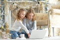 Portrait of teenage girls using laptop while sitting near Christmas tree Royalty Free Stock Photo