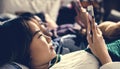 Teenage girls using smartphones on a bed internet in slumber par Royalty Free Stock Photo