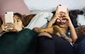 Teenage girls using smartphones on a bed internet in slumber party Royalty Free Stock Photo