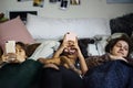 Teenage girls using smartphones on a bed in slumber party Royalty Free Stock Photo