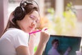 Teenage girls woman are e-learning online wearing headphones and learning from the tablet computers.