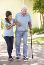 Teenage Granddaughter Helping Grandfather Out On Walk Royalty Free Stock Photo
