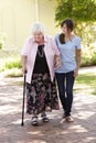 Teenage Granddaughter Helping Grandmother Out On Walk Royalty Free Stock Photo