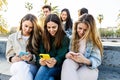 Teenage group of young people looking at smart mobile phone screen outdoors Royalty Free Stock Photo