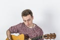 Teenage guitar player sits on a chair and plays western guitar Royalty Free Stock Photo