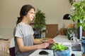 Teenage guy in headphones sitting at home using computer and a graphics tablet Royalty Free Stock Photo