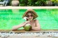 Teenage happy young girl enjoy her trip on vacation on tropical island in swimming pool with coconut juice Royalty Free Stock Photo