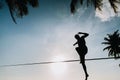 Teenage jumping on slackline with sky view