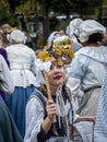 Teenage lady in traditional Danish costume holding up a venetian mask