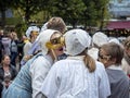 Teenage lady in traditional Danish costume holding up a Venetian Mask to her face