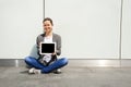 Teenage laughing while look at Ipad by the glass wall