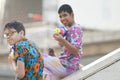 Teenage plays water with his friend during Songkran