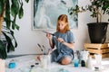 Teenage redhead girl is playing with brushes a workshop Royalty Free Stock Photo