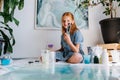 Smiling teenage redhead girl is holding bunch of brushes in hands Royalty Free Stock Photo