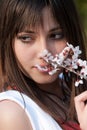 Teenage romantic girl holding branch of almond blossom