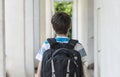 Teenage school boy with a backpack on his back walking to school