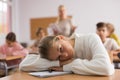 Teenage school girl lying at desk in classroom Royalty Free Stock Photo