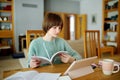 Teenage schoolgirl doing her homework with digital tablet at home. Child using gadgets to study. Education and distance learning Royalty Free Stock Photo