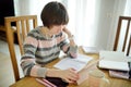 Teenage schoolgirl doing her homework with digital tablet at home. Child using gadgets to study. Education and distance learning Royalty Free Stock Photo