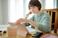 Teenage schoolgirl doing her homework with digital tablet at home. Child using gadgets to study. Education and distance learning Royalty Free Stock Photo