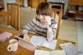 Teenage schoolgirl doing her homework with digital tablet at home. Child using gadgets to study. Education and distance learning Royalty Free Stock Photo