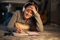 Schoolgirl at home doing her homework while listening to music with headphones