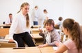 Teenage schoolgirls friendly talking during recess in classroom Royalty Free Stock Photo