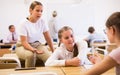 Teenage schoolgirls friendly talking during recess in classroom Royalty Free Stock Photo